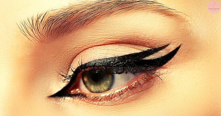a close-up of a well-groomed eye with dramatic, lifted natural eyelashes and bold winged eyeliner showcasing mascara application.