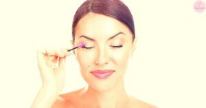 a person gently applying lash serum near the base of natural lashes with a precision brush.