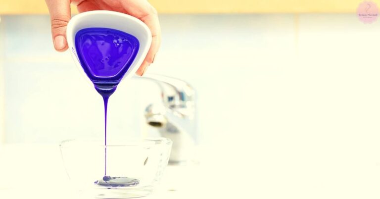 a hand pouring deep purple shampoo or toner into a glass container for hair color maintenance on lightened hair