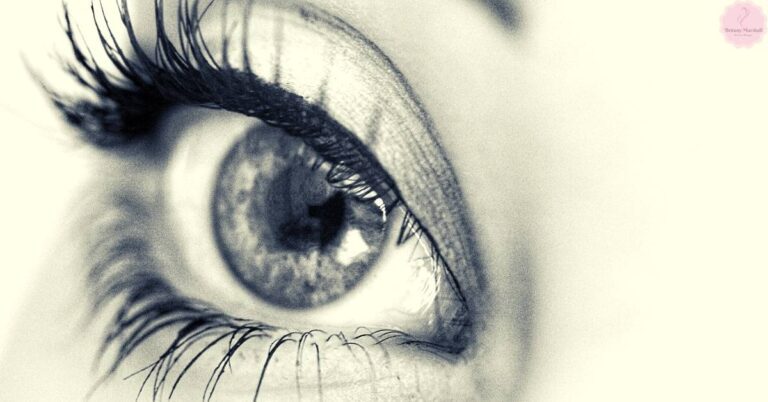a close-up black-and-white drawing of a human eye with detailed eyelashes, showcasing natural lash texture and curvature