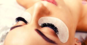 a lash technician applying doll eye lash extensions using individual false lashes on a client’s upper eyelid with precision mapping.