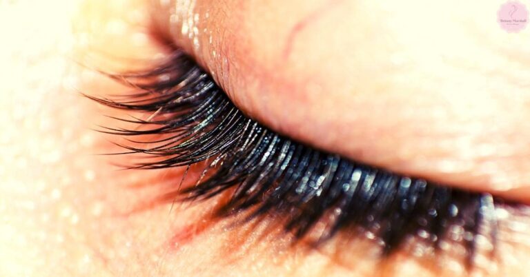 a close-up of false double eyelashes applied with eyelash glue on an eyelid