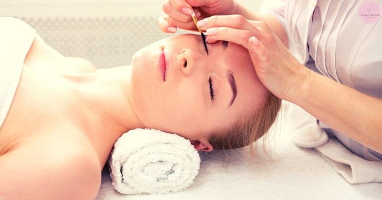 a professional performing eyelash tinting on a relaxed client using precision tools