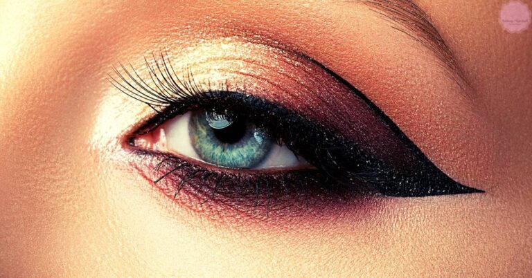 a close-up of an eye with dramatic winged eyeliner and cool-toned eyeshadow under the lid, emphasizing depth and expressive features.