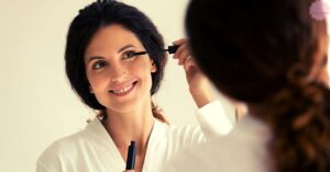 a professional applying mascara to enhance eyelashes for a fuller look during a beauty treatment session