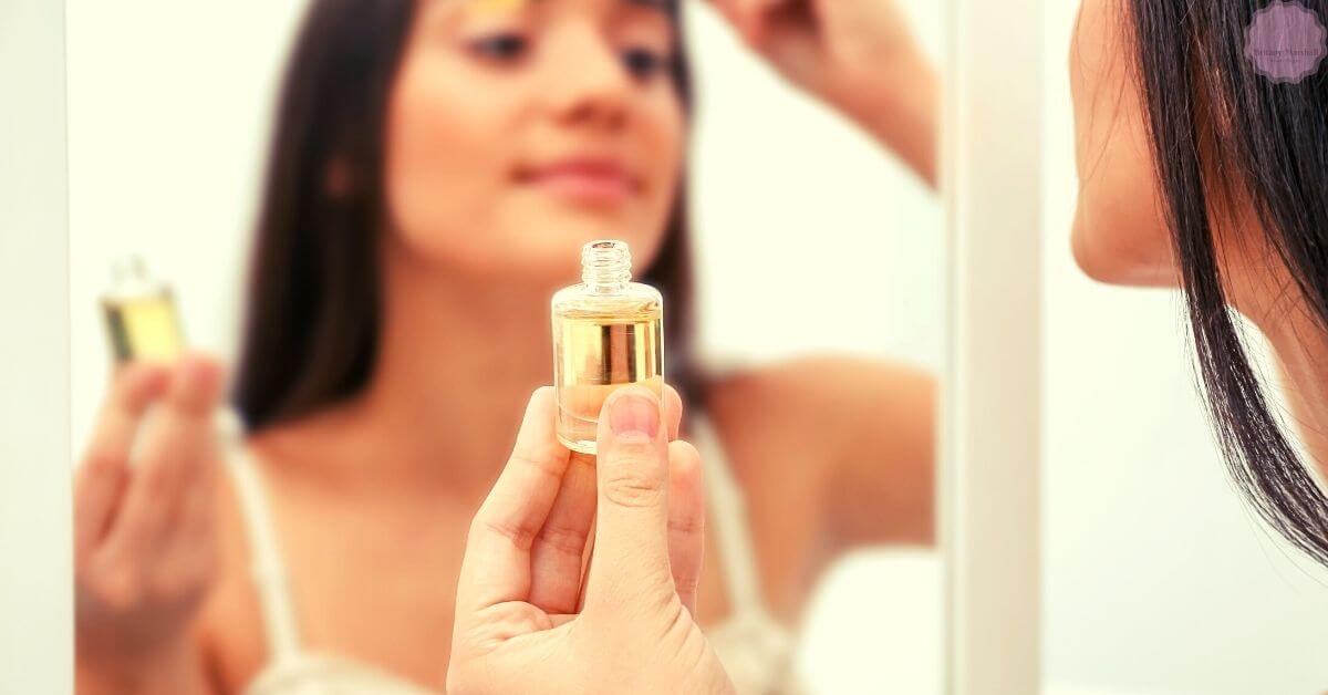 a person holding a small bottle of castor oil while examining their reflection, focusing on eyelash care