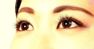 a close-up comparison of natural eyelashes versus enhanced eyelashes with noticeable length and thickness differences.