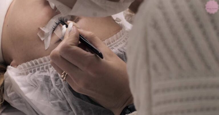 a person receiving eyelash extensions with tape applied to the lash line, showing potential irritation or dryness at the base.