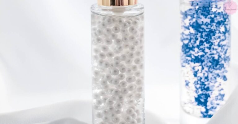 a clear bottle filled with tiny magnetic eyelash extension cleanser beads, and a blue-tinted liquid in a separate container