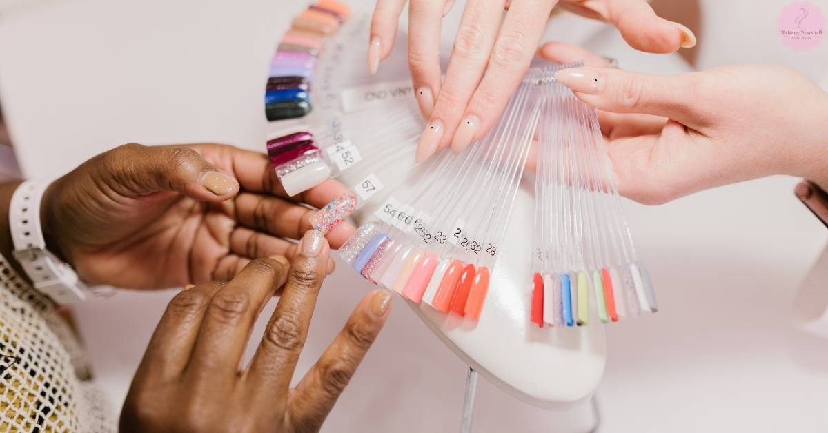 a pair of hands selecting poly gel nail colors and corresponding UV lamps for artificial nail enhancement.