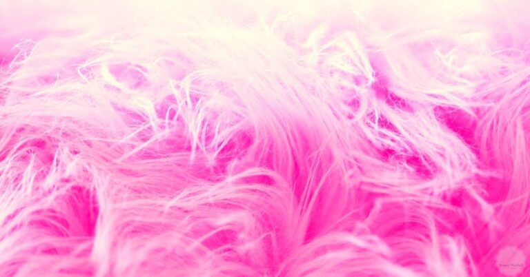 a close-up microscopic view of bleached hair strands showing damaged, frayed cuticles and lightened pink fibers.