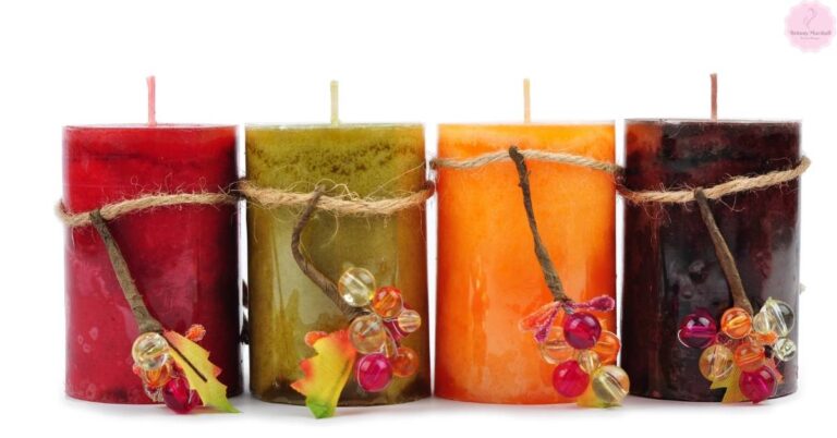 four vibrant handmade candles with twine-wrapped bases, adorned with decorative beads and dried elements, showcasing deep red, olive green, orange, and dark brown wax colors.