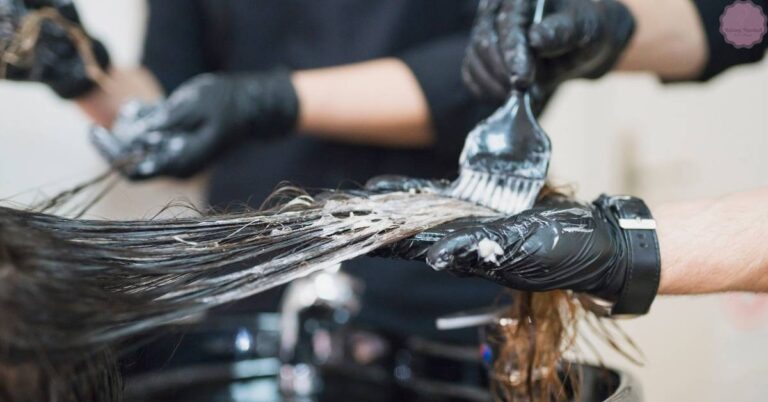 a hairstylist mixing semi-permanent hair dye with developer using a brush on gloved hands