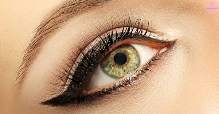 a close-up of a human eye with long, voluminous eyelash extensions and precisely applied black eyeliner along the upper lash line