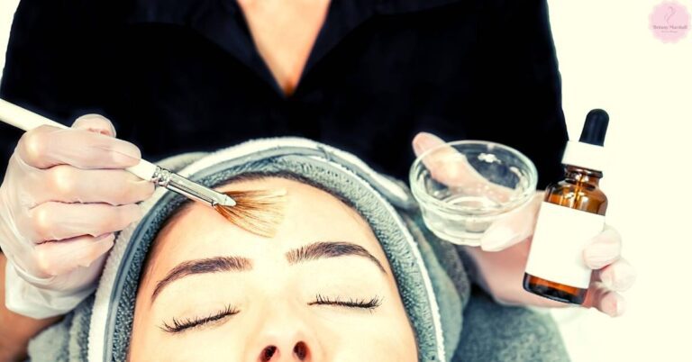 a person receiving a gentle facial treatment with a soft brush application, likely part of post-care for sensitive skin during the healing process after a chemical peel.
