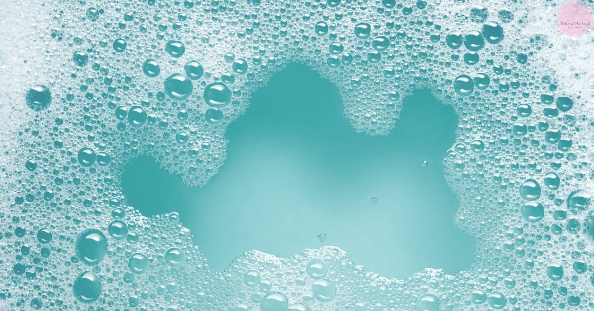 water droplets forming a heart shape surrounded by bubbles, evoking freshness and purity