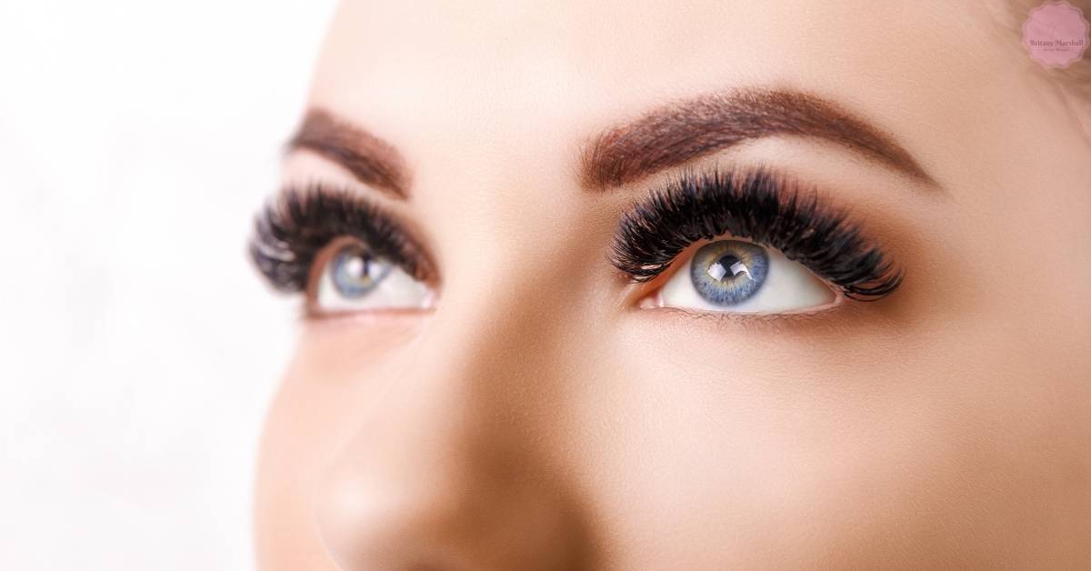 a close-up of a person’s eye with long, voluminous eyelashes showcasing potential results of natural eyelash care