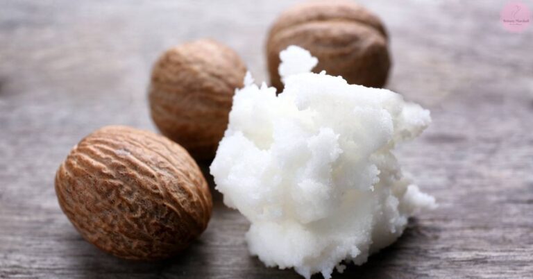 whole walnuts with extracted shea butter flakes on a textured surface