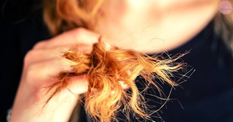 a close-up of someone holding a strand of dry, frizzy hair ends curling from heat or damage, highlighting texture issues.