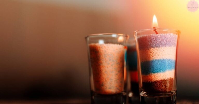 two lit votive candles in glass containers with layered colored wax, one lit and one unlit, useful for candle making measurements