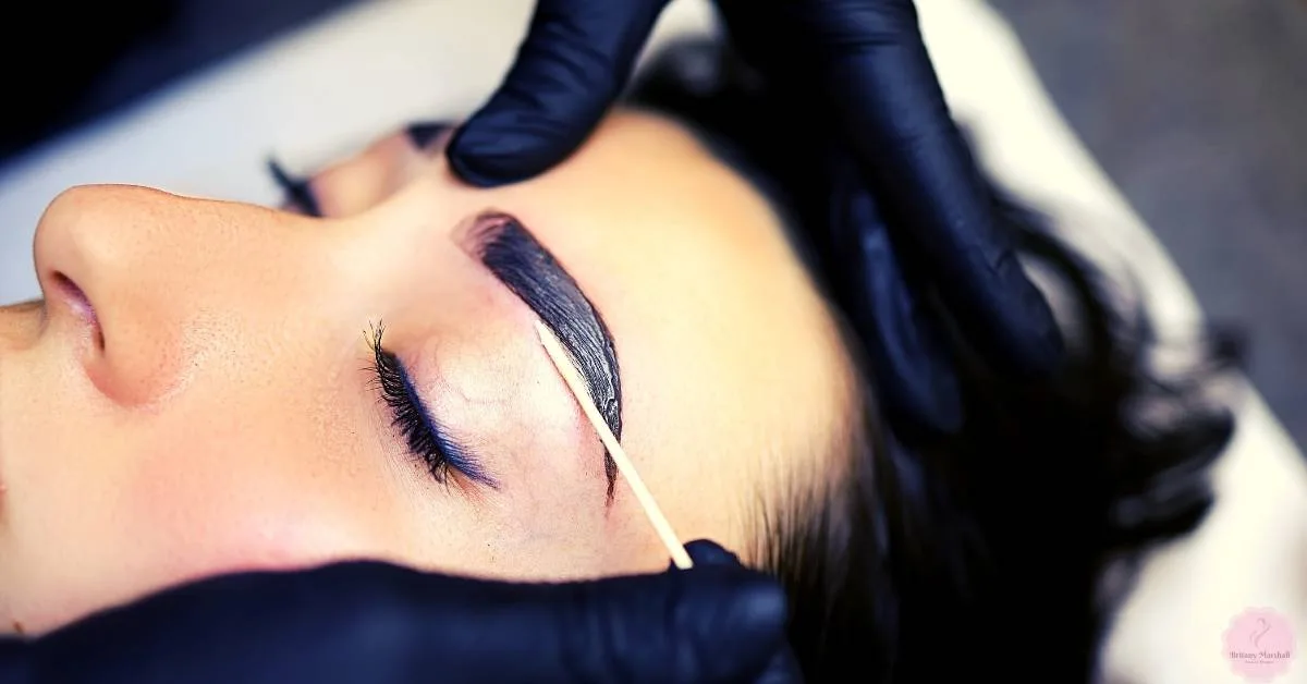 a person receiving a professional eyebrow tinting treatment for natural eyebrow darkening and enhancement
