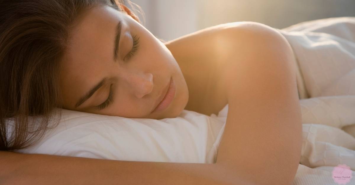a person peacefully sleeping on their side with eyelash extensions visible.
