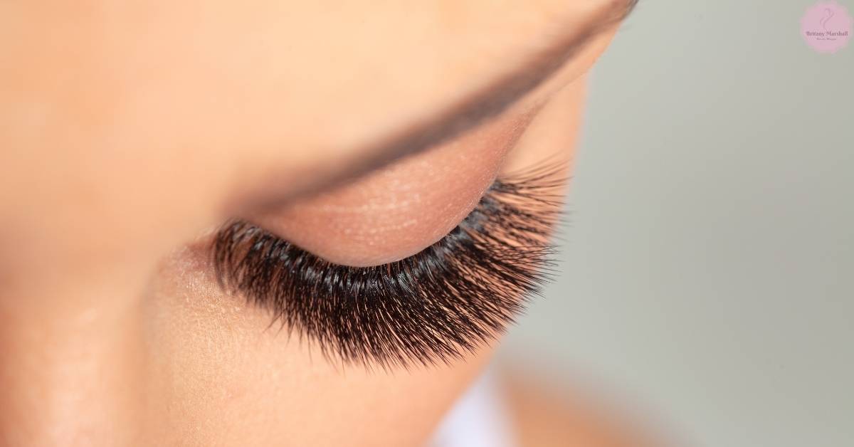 a close-up of a person’s eye showcasing long, voluminous, curled eyelashes with a smooth, lifted lash line.