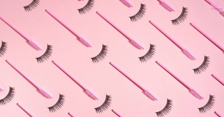 a collection of individual lash trays with false eyelash extensions arranged in an organized diagonal pattern on a pastel pink background