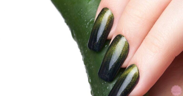 a hand showcasing dark green ombre coffin nails with shimmery accents against a fresh aloe vera leaf background