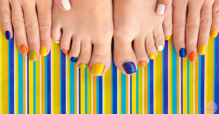 a pair of feet showcasing bright, short coffin acrylic nails in vibrant colors and bold stripes against a matching background