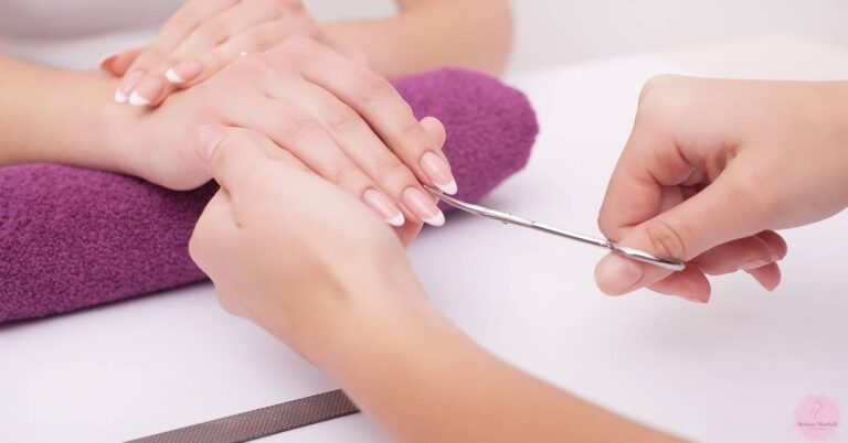 a professional nail technician trimming an almond-shaped nail with precision near the cuticle for elegant french tip inspiration.