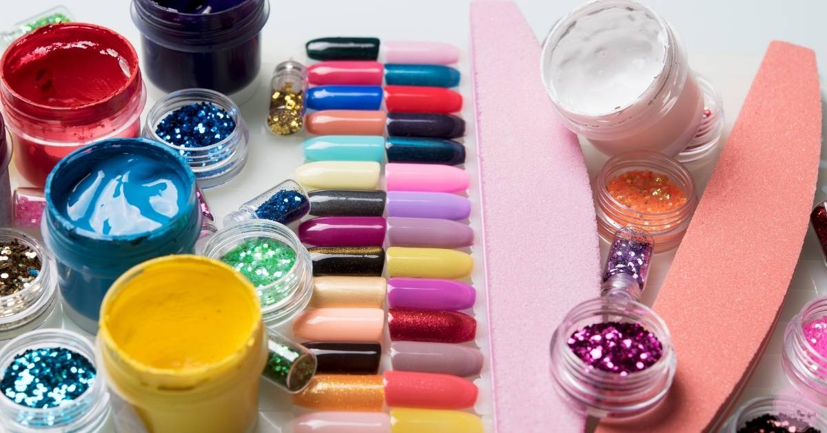 a collection of colorful nail polish, glue, and glitter supplies for press-on nails including acetone-free polish removers and decorative nail kits