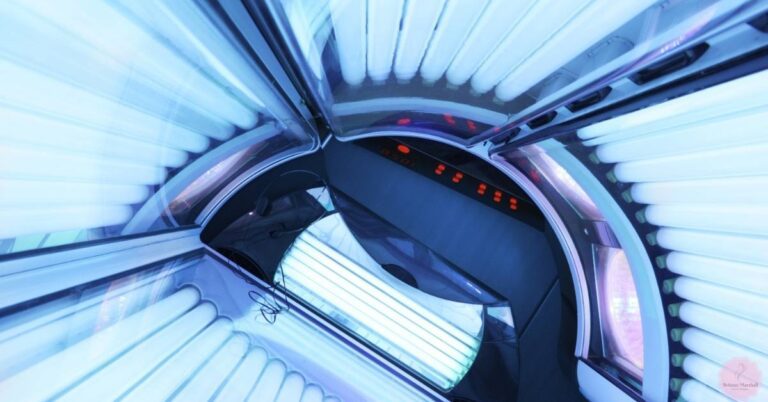 an interior view of a tanning bed with ultraviolet lamps emitting blue-toned light
