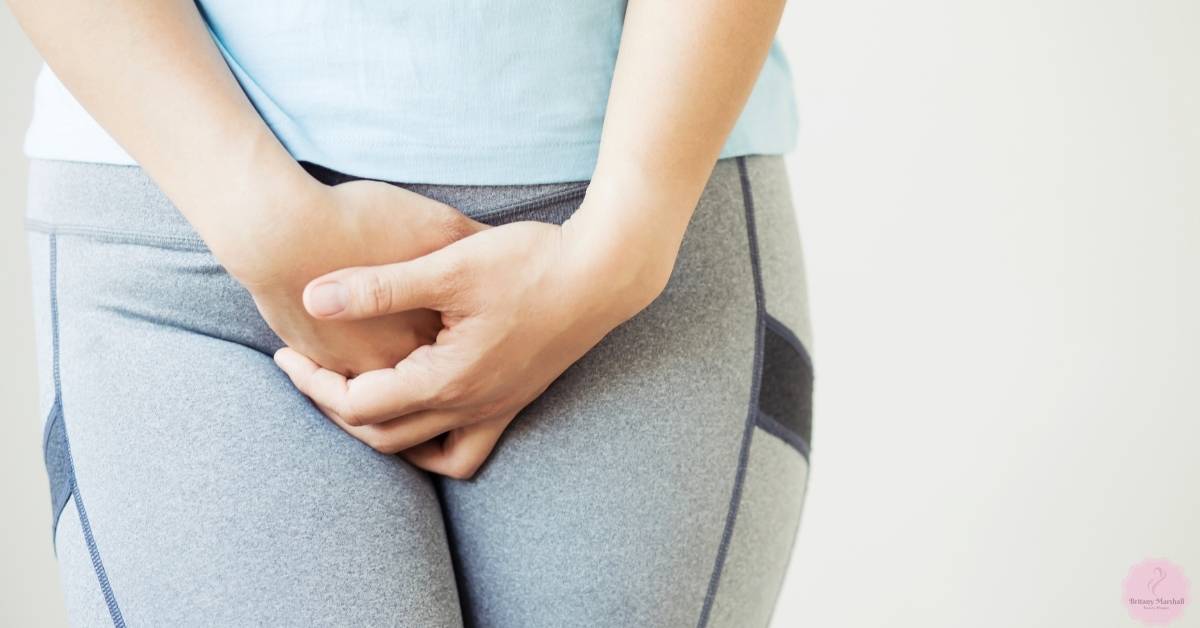 a person holding lower abdomen area indicating potential skin irritation from tight clothing and friction