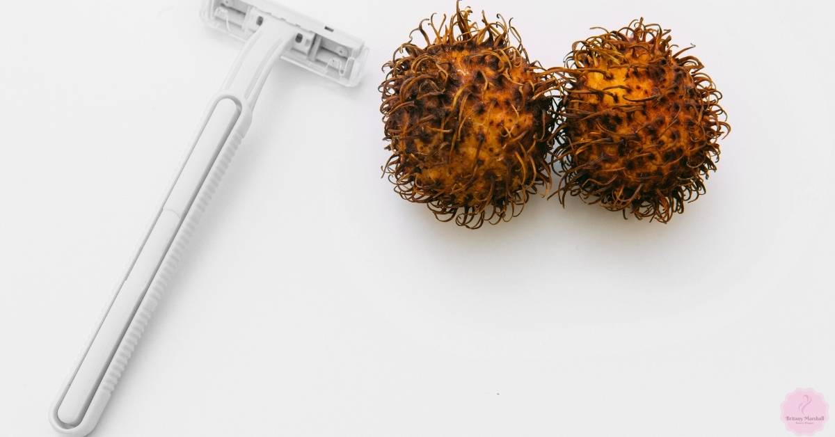 a used depilatory cream applicator beside two clumps of removed pubic hair after hair removal