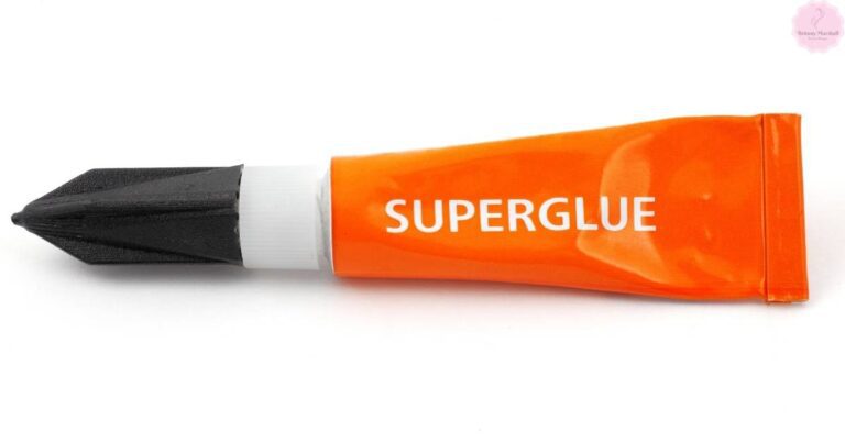 an orange tube of super glue with a black precision nozzle for precise application