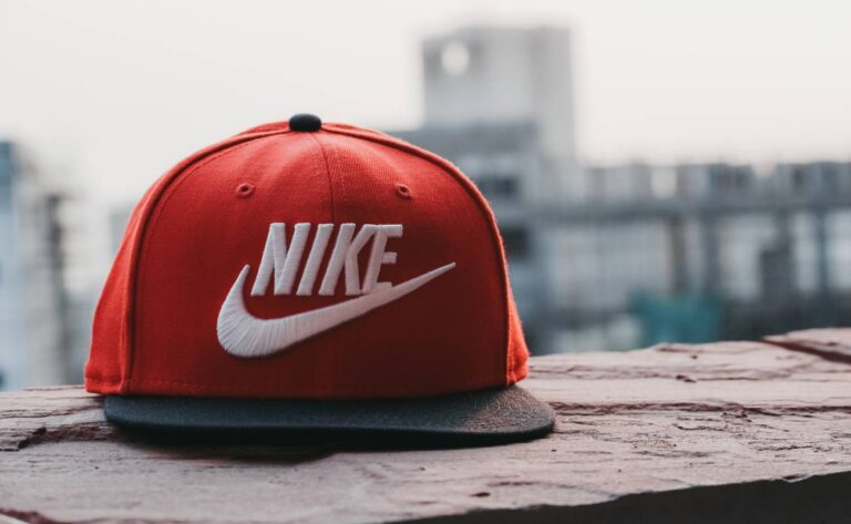 a red Nike baseball cap featuring the iconic white swoosh logo, highlighting the brand’s enduring popularity in athletic fashion.