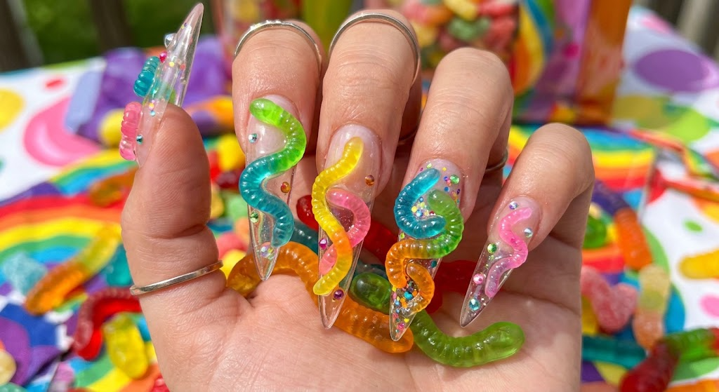 Goofy nails design showcasing colorful translucent 3D gummy worm charms wrapped on stiletto tips