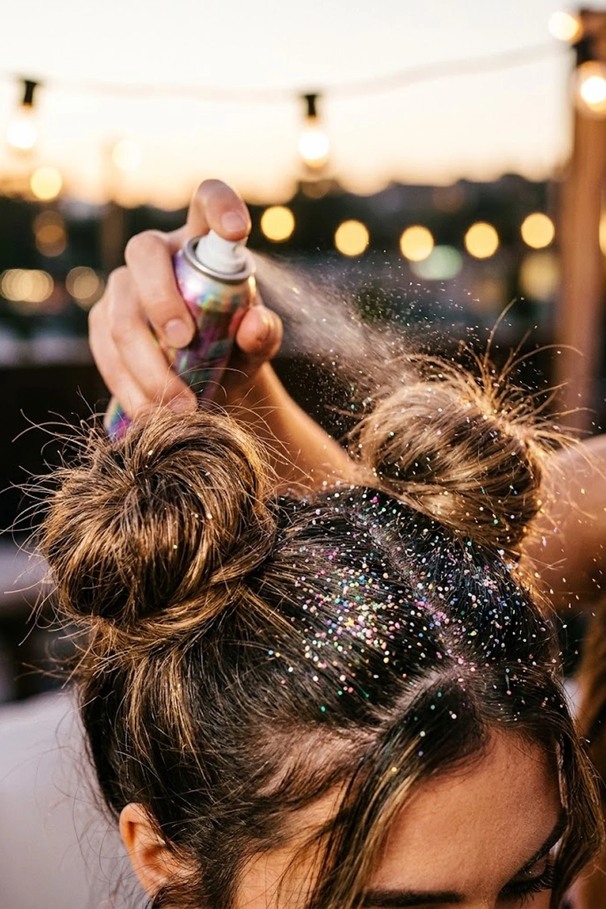 Editorial close-up of double high space buns misted with fine holographic hair glitter aerosol spray sparkling under warm evening lights (AI Generated Image)