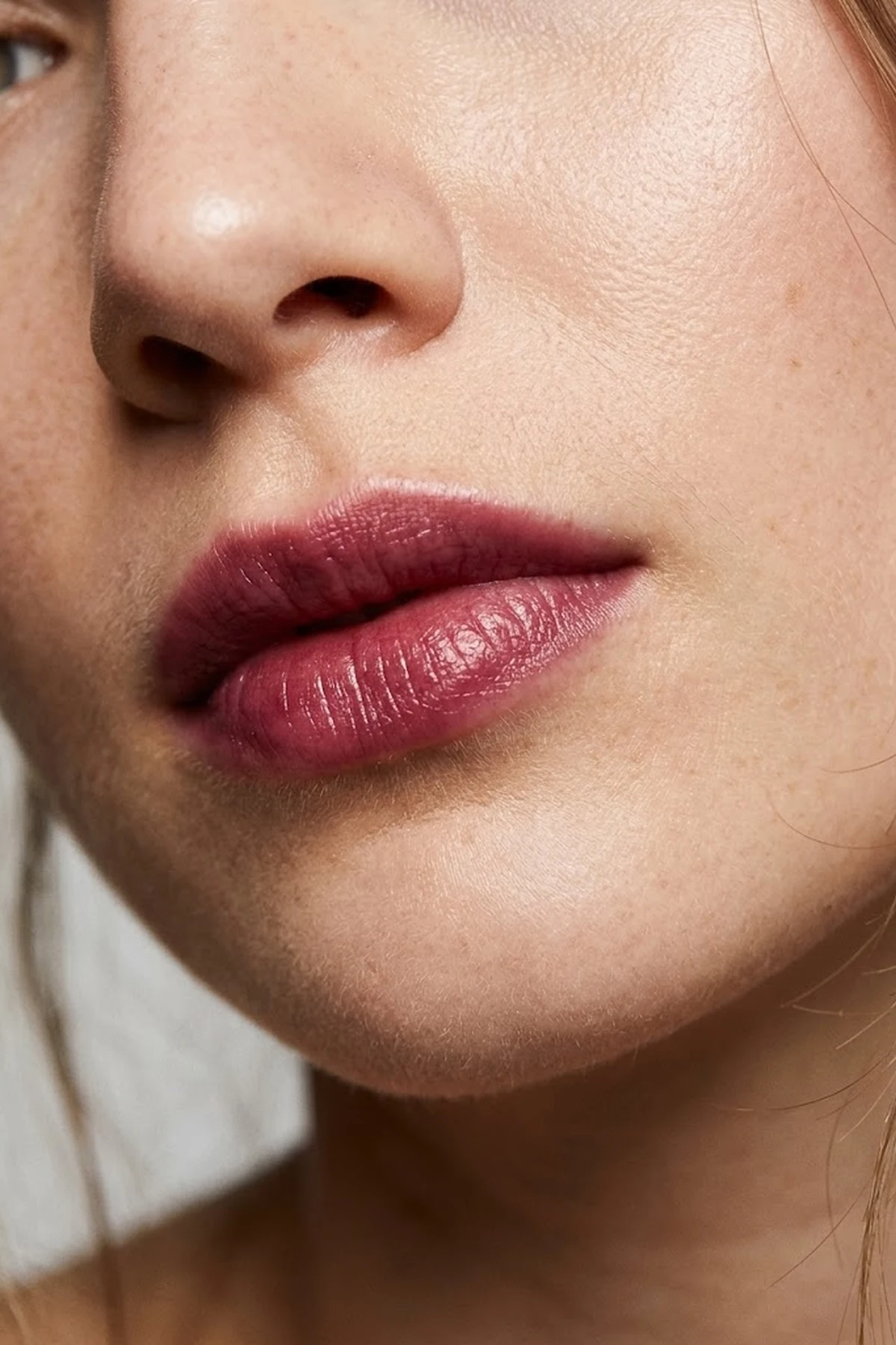 20 Effortless Natural Makeup Looks for an Everyday 'No-Makeup' Glow (2026 Inspo) 36 Close-up editorial portrait focusing on soft blotted berry lips with diffused edges and a hydrating balm sheen against bare glowing skin (AI Generated Image)